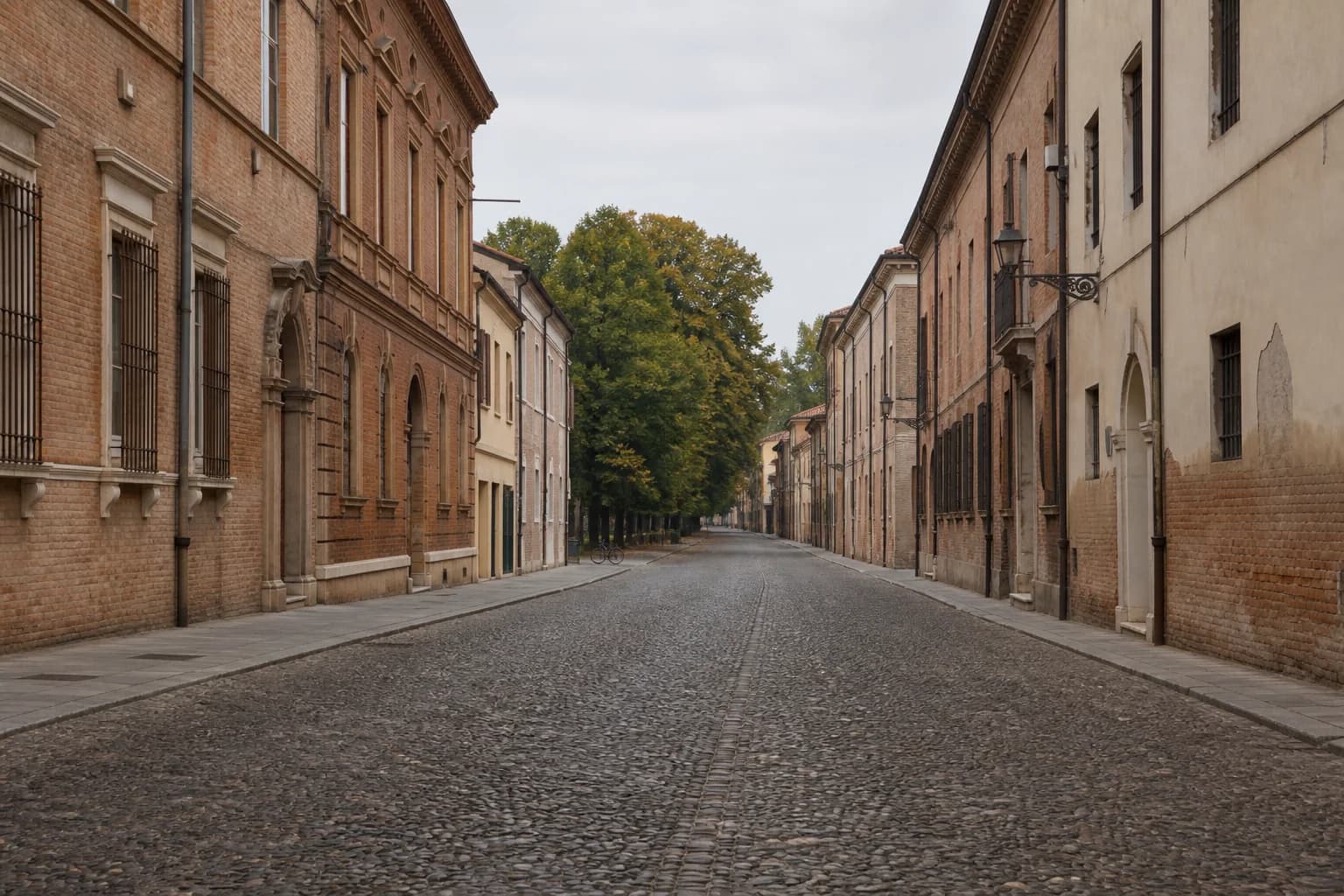 The long cobbled perspective of Corso Ercole I d’Este between red-brick Renaissance palazzi in Ferrara